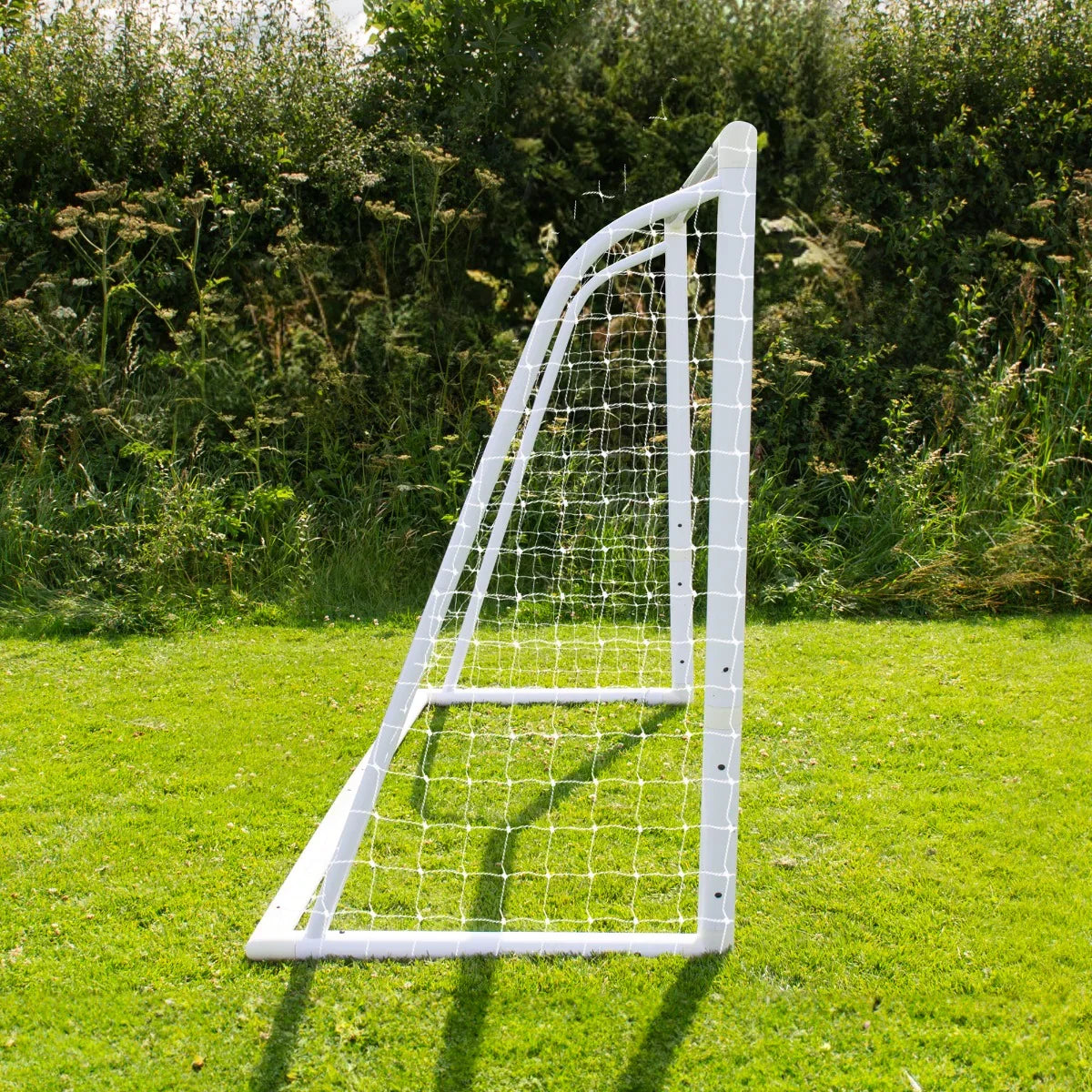 6 x 4ft white football goal with netting, set on green grass, showcasing sturdy frame and angled design for outdoor play