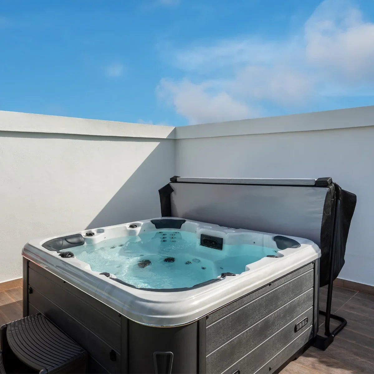 2.1m black hot tub spa cover on a modern spa, showcasing sleek design, durable material, and clear blue water under a bright sky