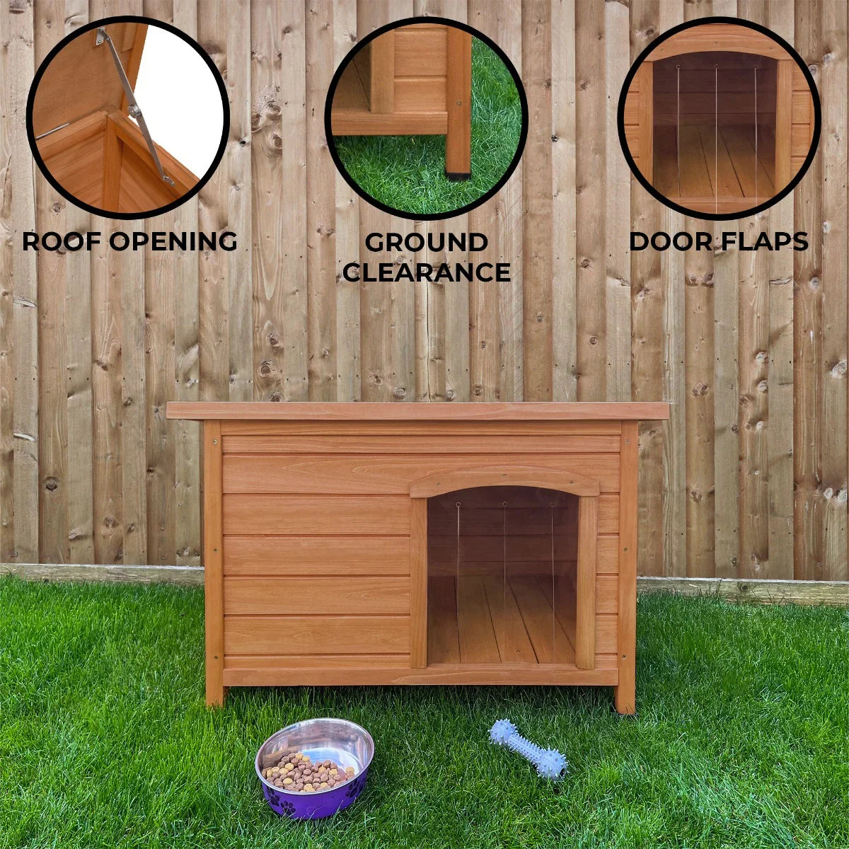 Small wooden dog kennel with a slanted roof, ground clearance, and door flaps, set on green grass against a wooden fence