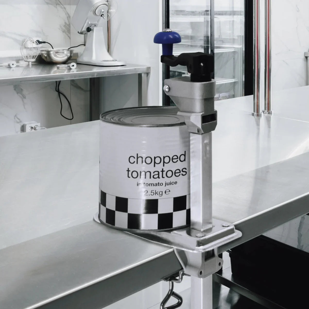 KuKoo Commercial Tin Can Opener with blue handle, securely holding a can of chopped tomatoes on a stainless steel countertop