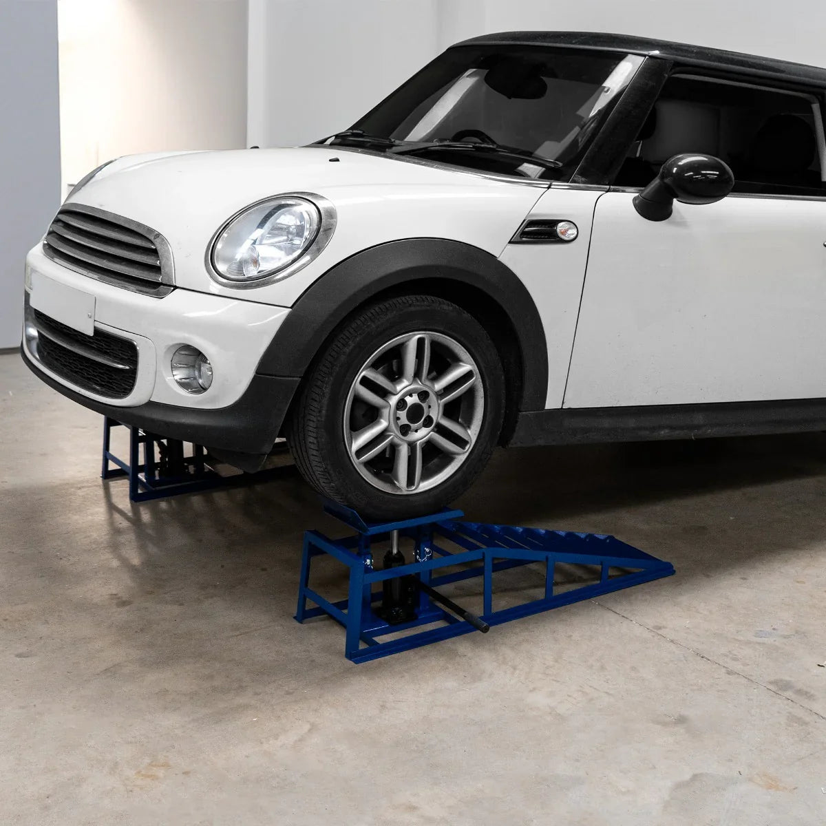 Hydraulic car ramps in blue, supporting a white Mini Cooper, designed for vehicles up to 3 tonnes, with a sturdy, textured surface