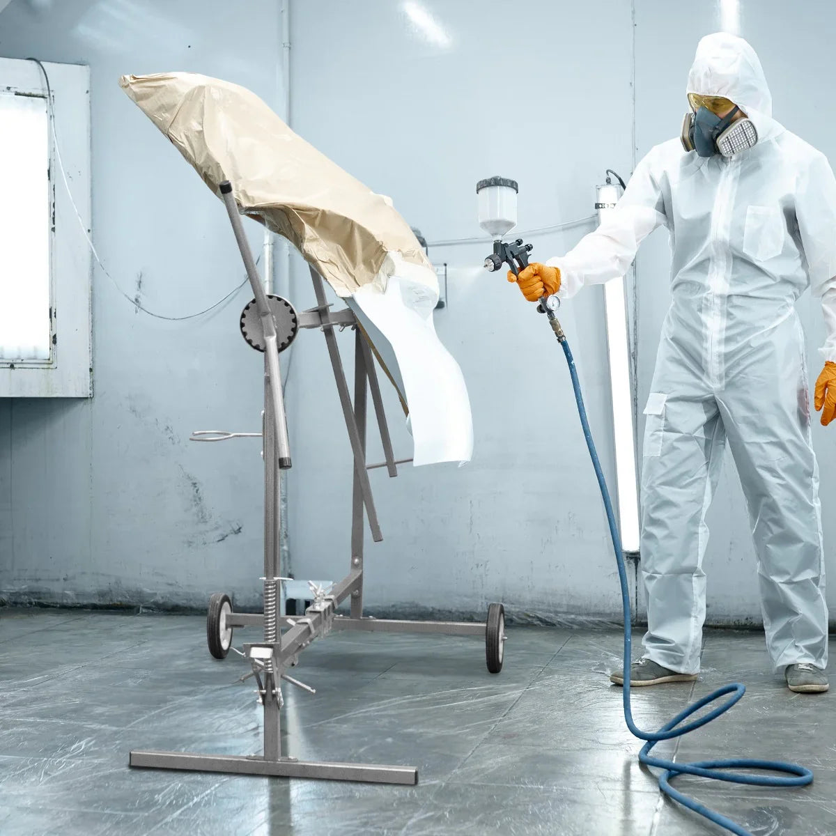 T-Mech Rotary Paint Panel Stand in a workshop, featuring a sturdy metal frame, adjustable height, and a protective cover on a painted panel