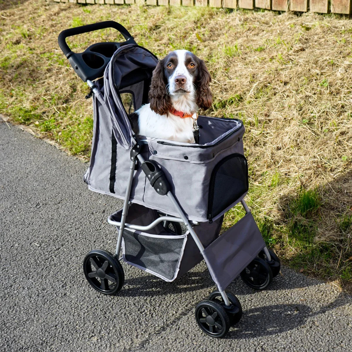 Grey pet stroller featuring a spacious mesh compartment, sturdy wheels, and a rain cover, perfect for outdoor adventures with your dog