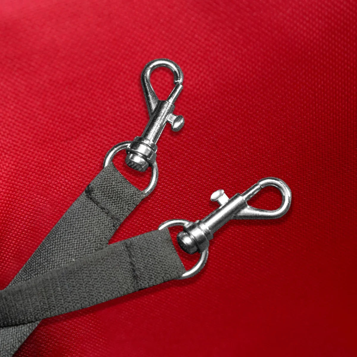 Durable metal clips attached to gray straps on a vibrant red pet stroller, designed for secure and comfortable pet transport