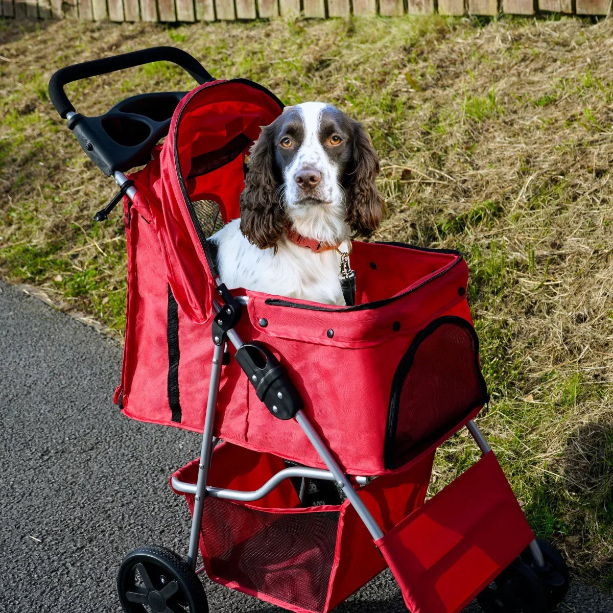 Red pet stroller featuring a spacious mesh compartment, sturdy wheels, and a rain cover, perfect for outdoor adventures with pets