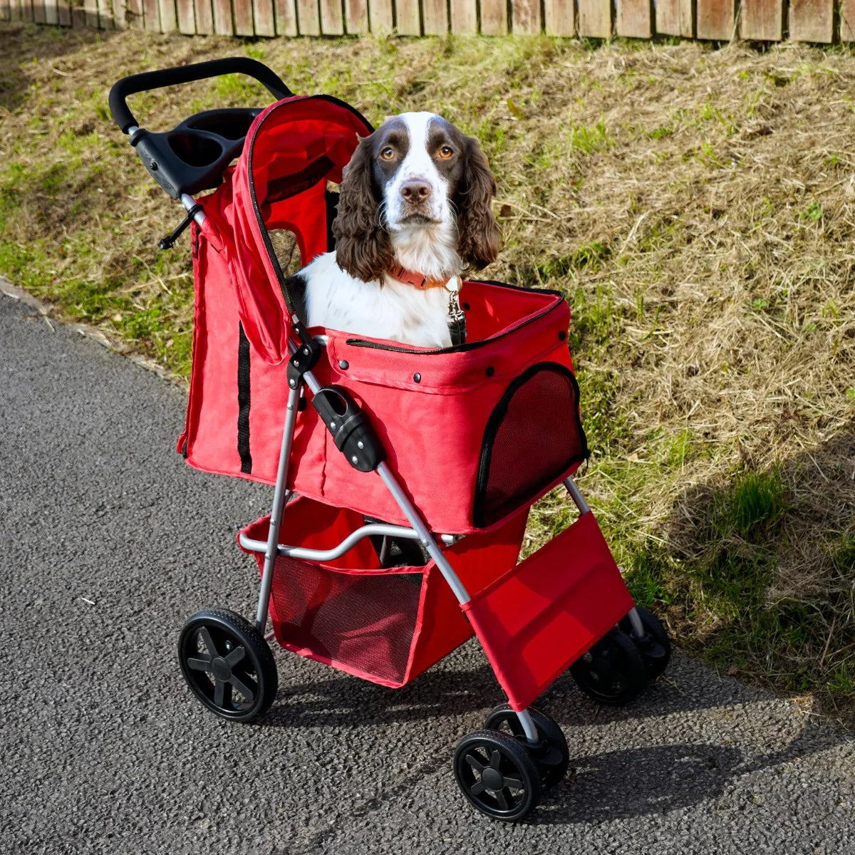 Red pet stroller with rain cover, featuring a spacious mesh compartment, sturdy wheels, and a comfortable interior for dogs
