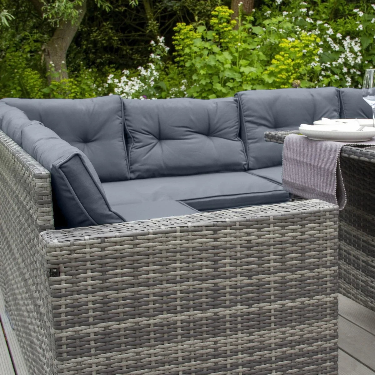 Grey rattan corner set featuring plush cushions, ideal for outdoor lounging, with a stylish woven texture and modern design