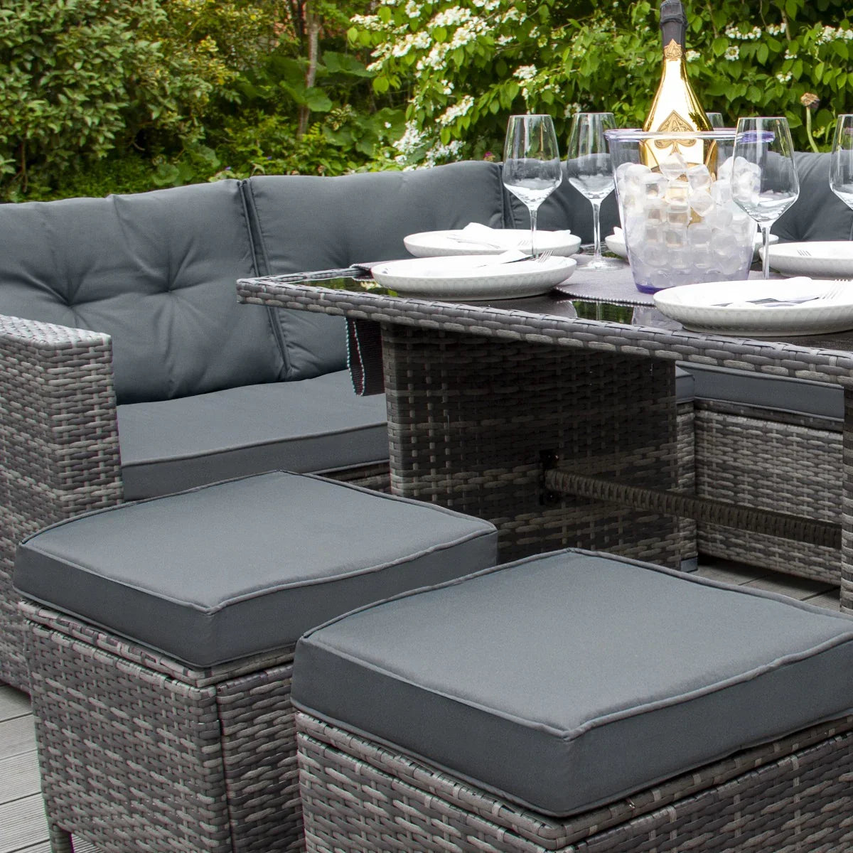 Grey rattan corner set featuring plush cushions, a sleek glass-top table, and stylish seating, perfect for outdoor gatherings
