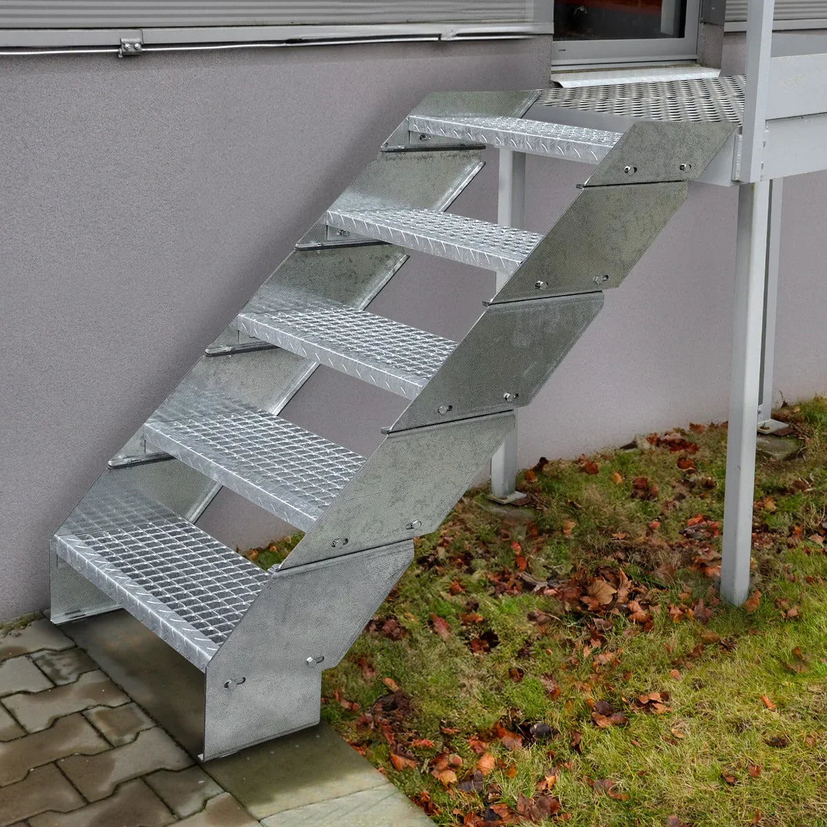 Galvanised adjustable staircase with two sections, 900mm wide, featuring a textured surface and sturdy metal construction, set on grass
