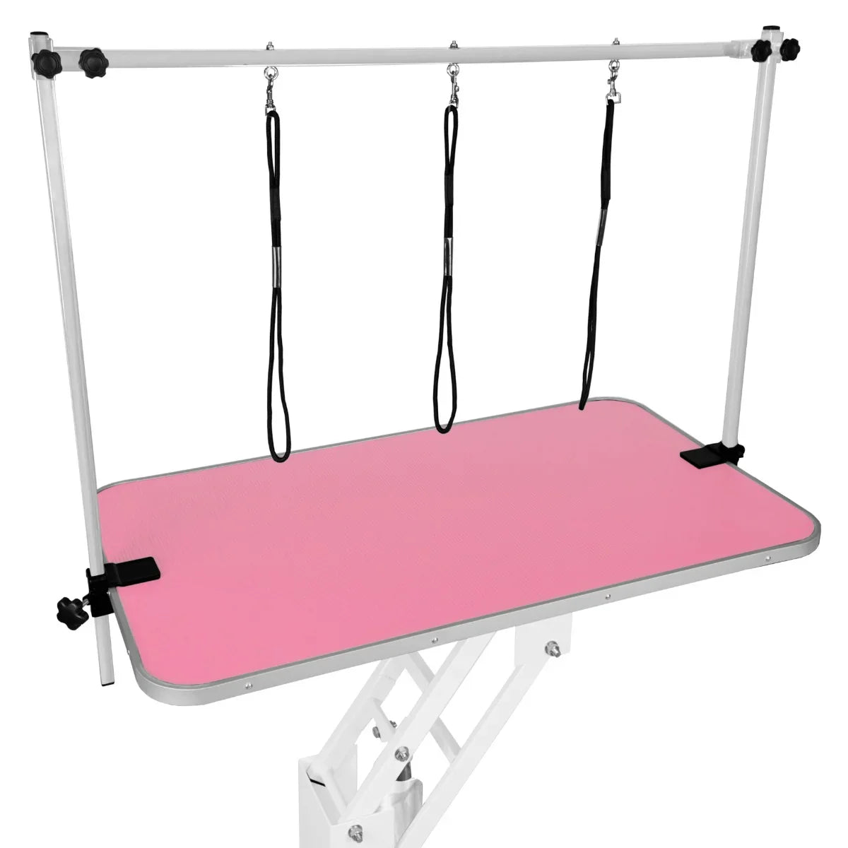 White hydraulic grooming table with a pink textured top, featuring adjustable arm supports and leashes for pet grooming