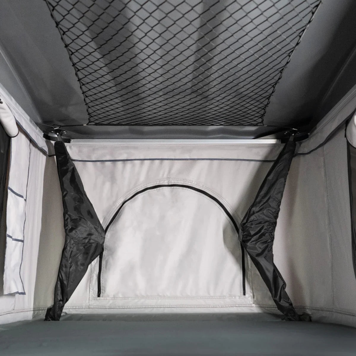 Grey car roof tent interior featuring spacious sleeping area, mesh storage net, and durable fabric for outdoor adventures