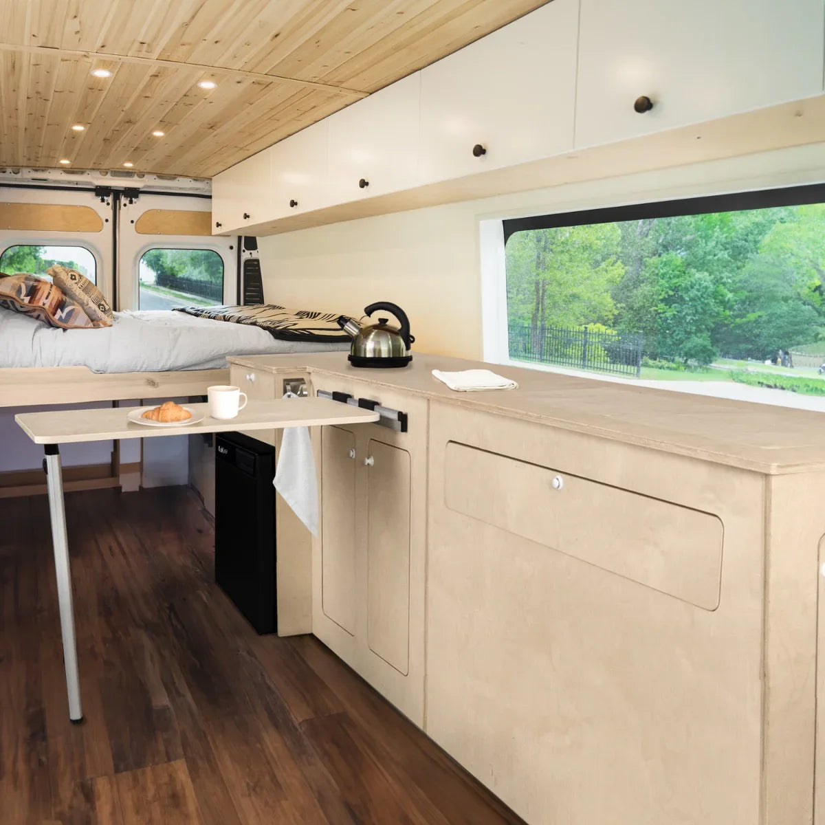 Light wood Camper Kitchen Pod with a compact design, featuring a foldable table, sink, and storage, set in a cozy van interior