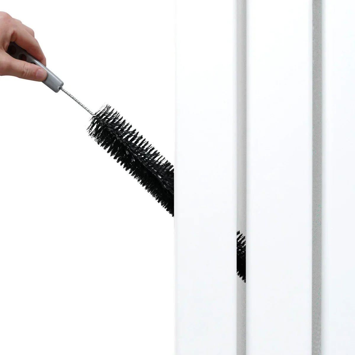 White flat mirror radiator with a hand holding a cleaning brush, showcasing its sleek design and easy maintenance features
