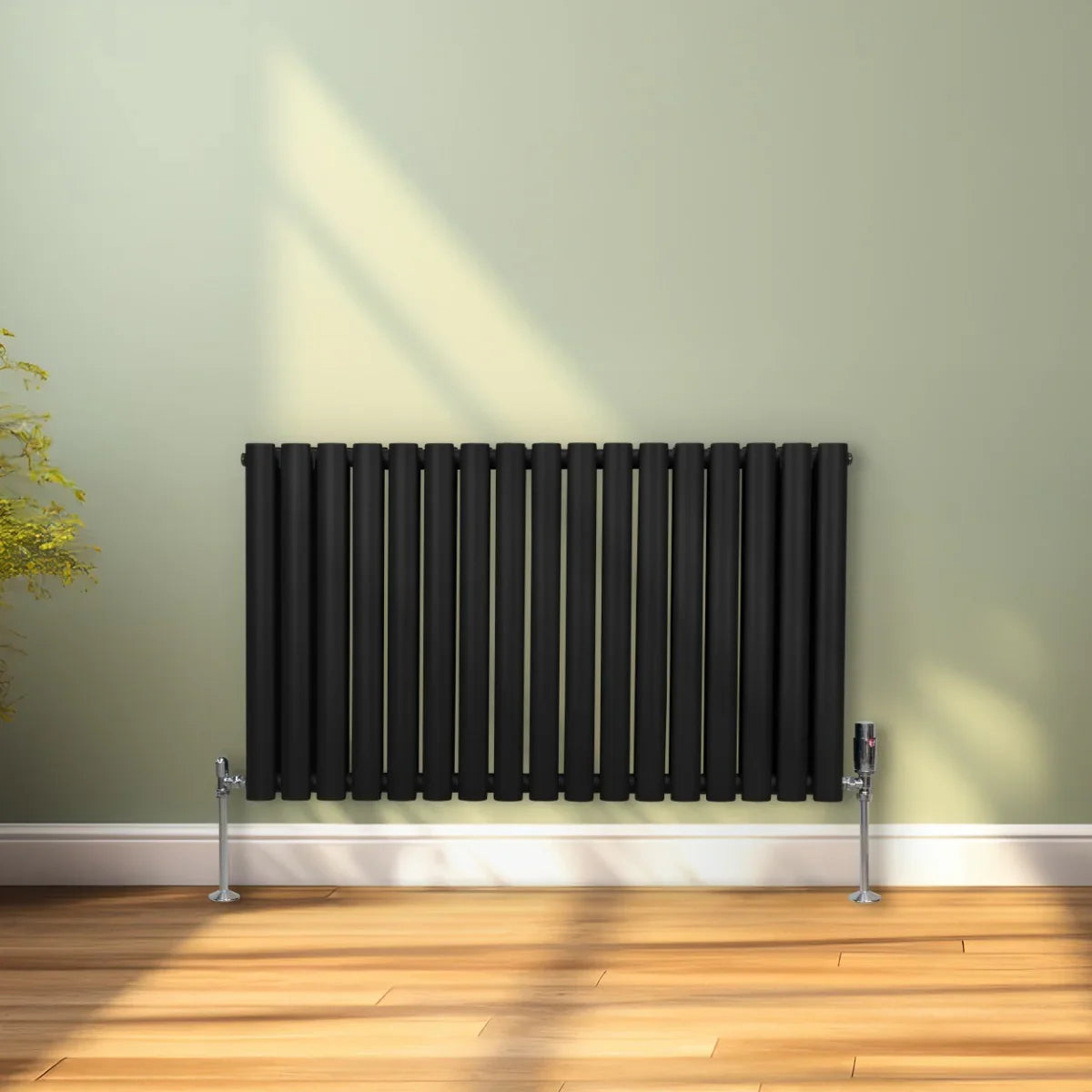 Sleek black oval column radiator, 600mm x 1020mm, featuring vertical bars and modern design, mounted on a light green wall