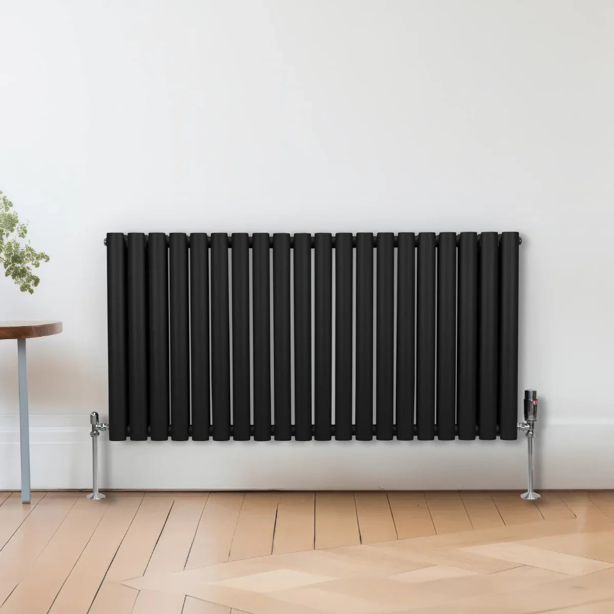 Black oval column radiator measuring 600mm x 1200mm, featuring a sleek design with vertical slats, mounted on silver feet
