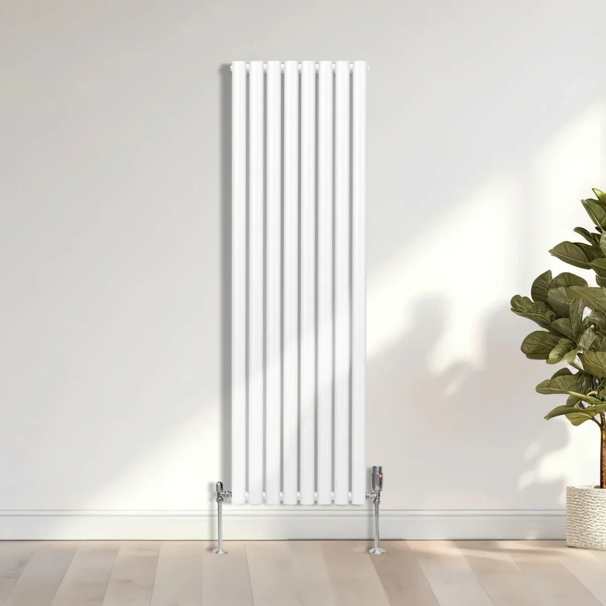 Sleek white oval column radiator, 1600mm x 480mm, featuring vertical bars and chrome feet, set against a minimalist wall and floor