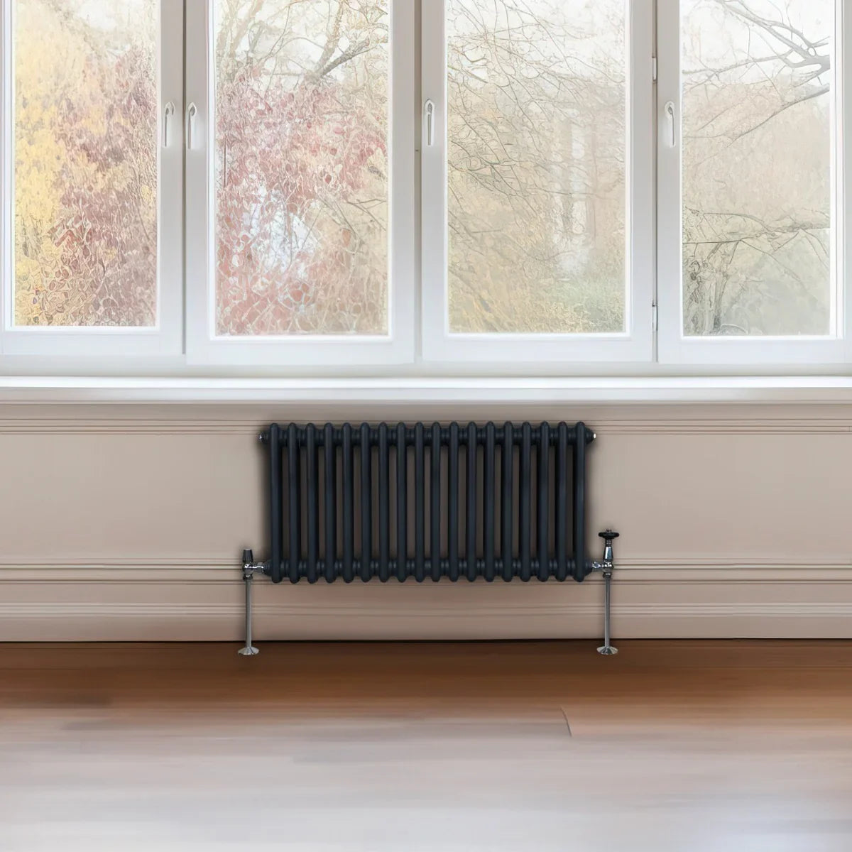 Traditional 2 column radiator in anthracite grey, featuring a sleek design with vertical fins, positioned beneath a large window