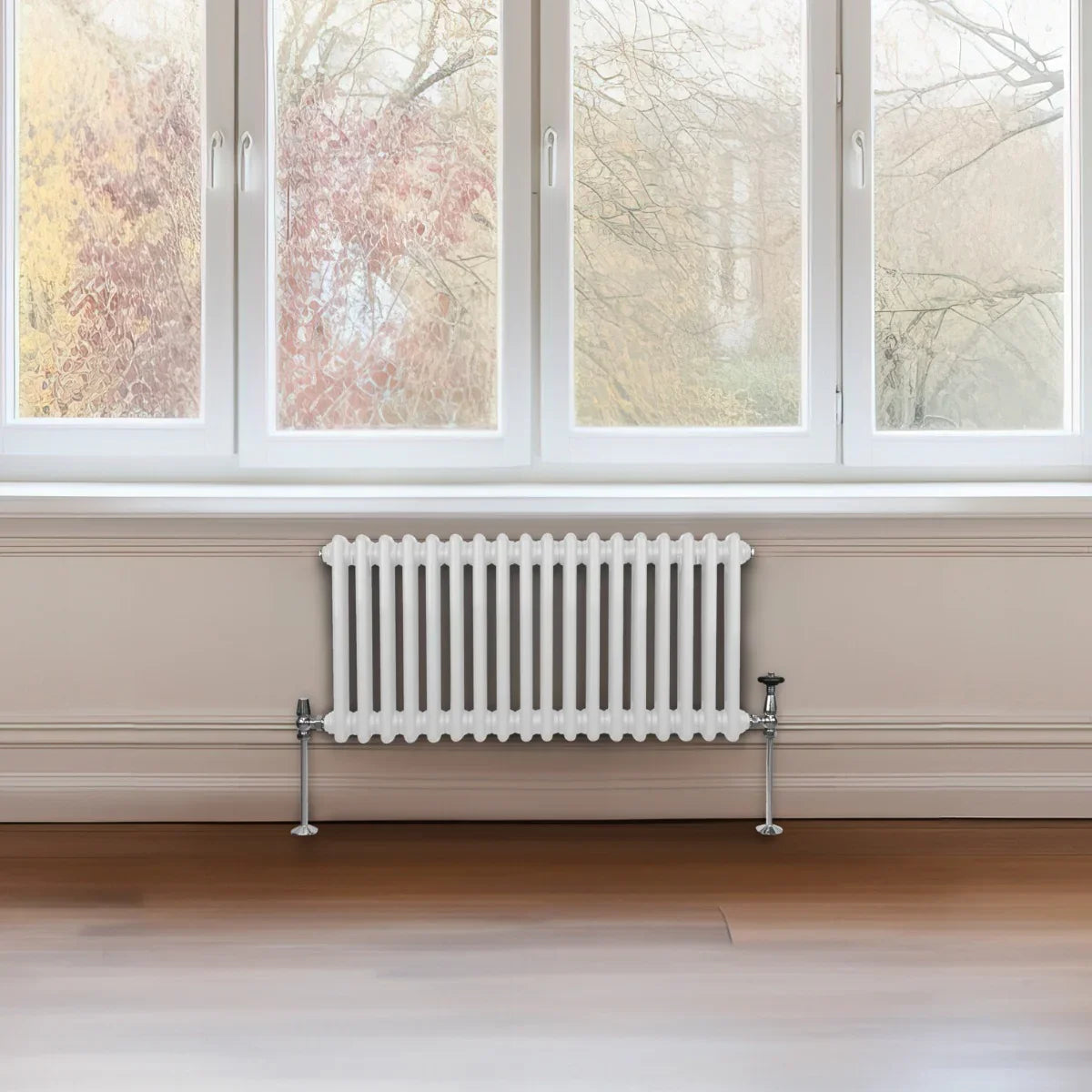 Traditional white 2 column radiator with a sleek design, positioned beneath a large window in a modern interior setting