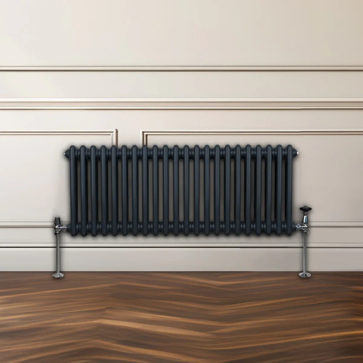 Traditional 2 column radiator in anthracite grey, featuring sleek vertical bars and chrome feet, set against a neutral wall and wooden floor