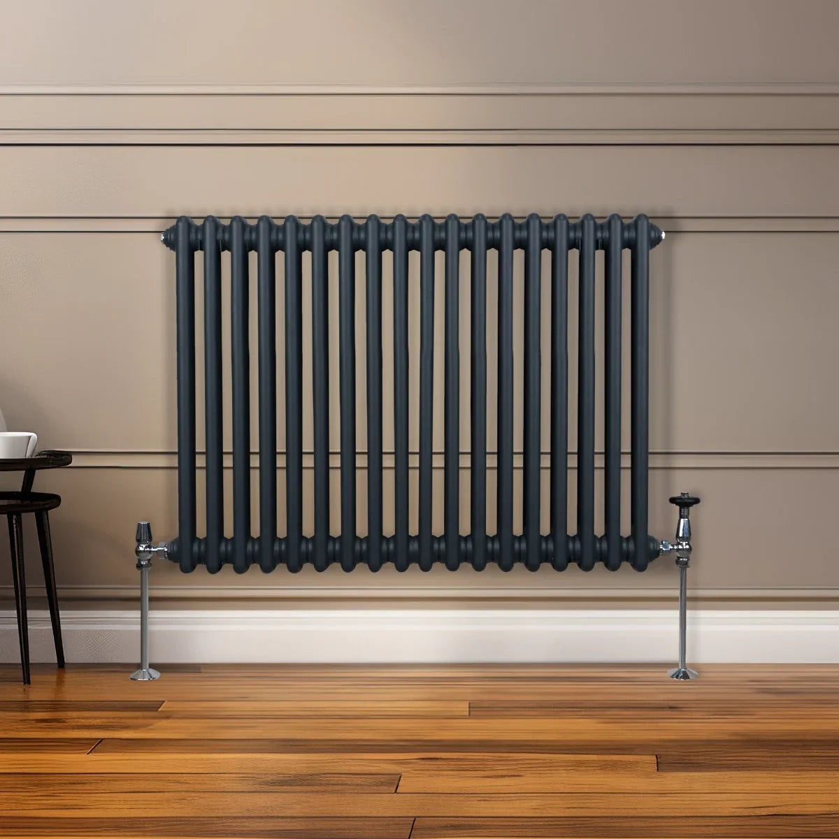 Traditional 2 column radiator in anthracite grey, featuring a sleek design with vertical bars, mounted on a wooden floor against a wall