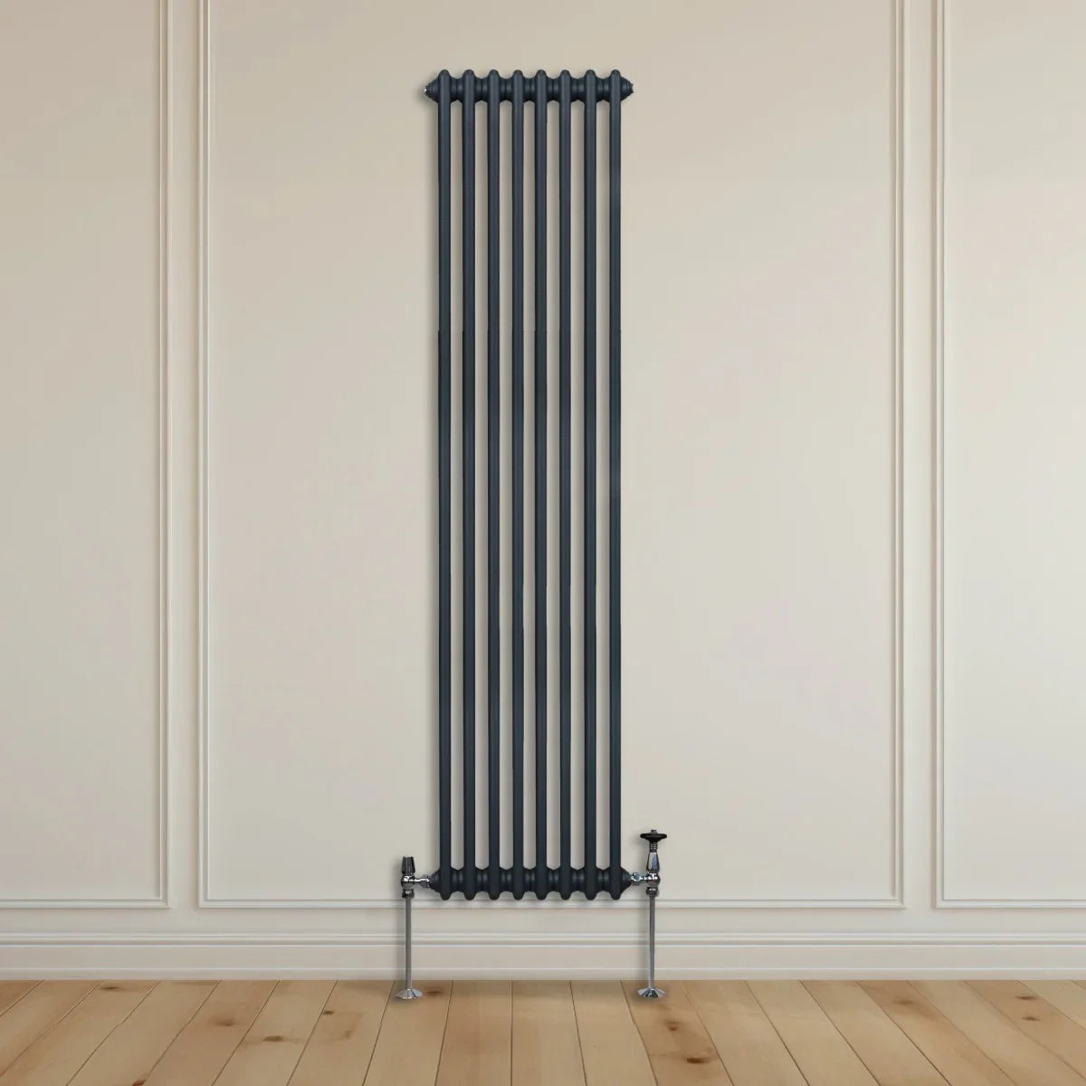 Traditional 2 column radiator in anthracite grey, tall and slim design, mounted on a light-colored wall with wooden flooring