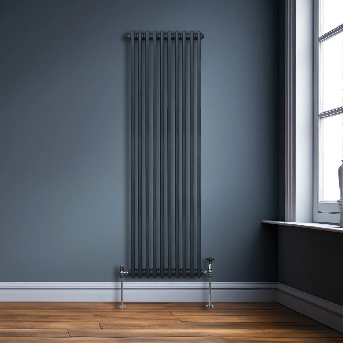 Traditional 2 column radiator in anthracite grey, featuring vertical bars, sleek design, and positioned against a blue wall with wooden floor