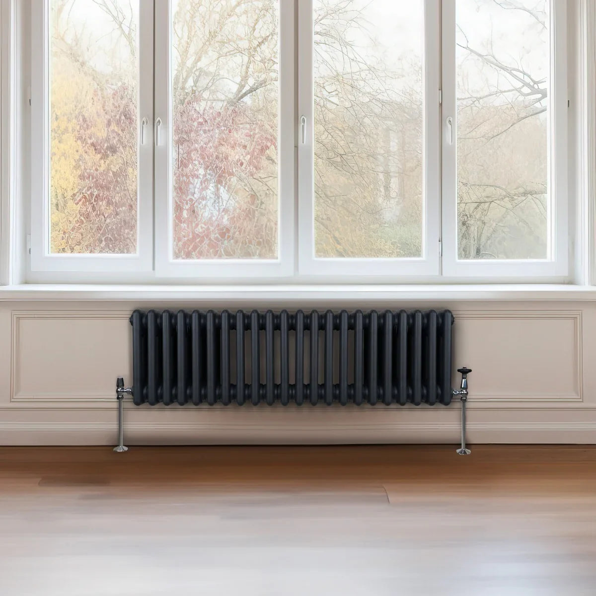 Traditional anthracite grey 3 column radiator, 300 x 1012mm, featuring a sleek design and mounted on a wall beneath large windows