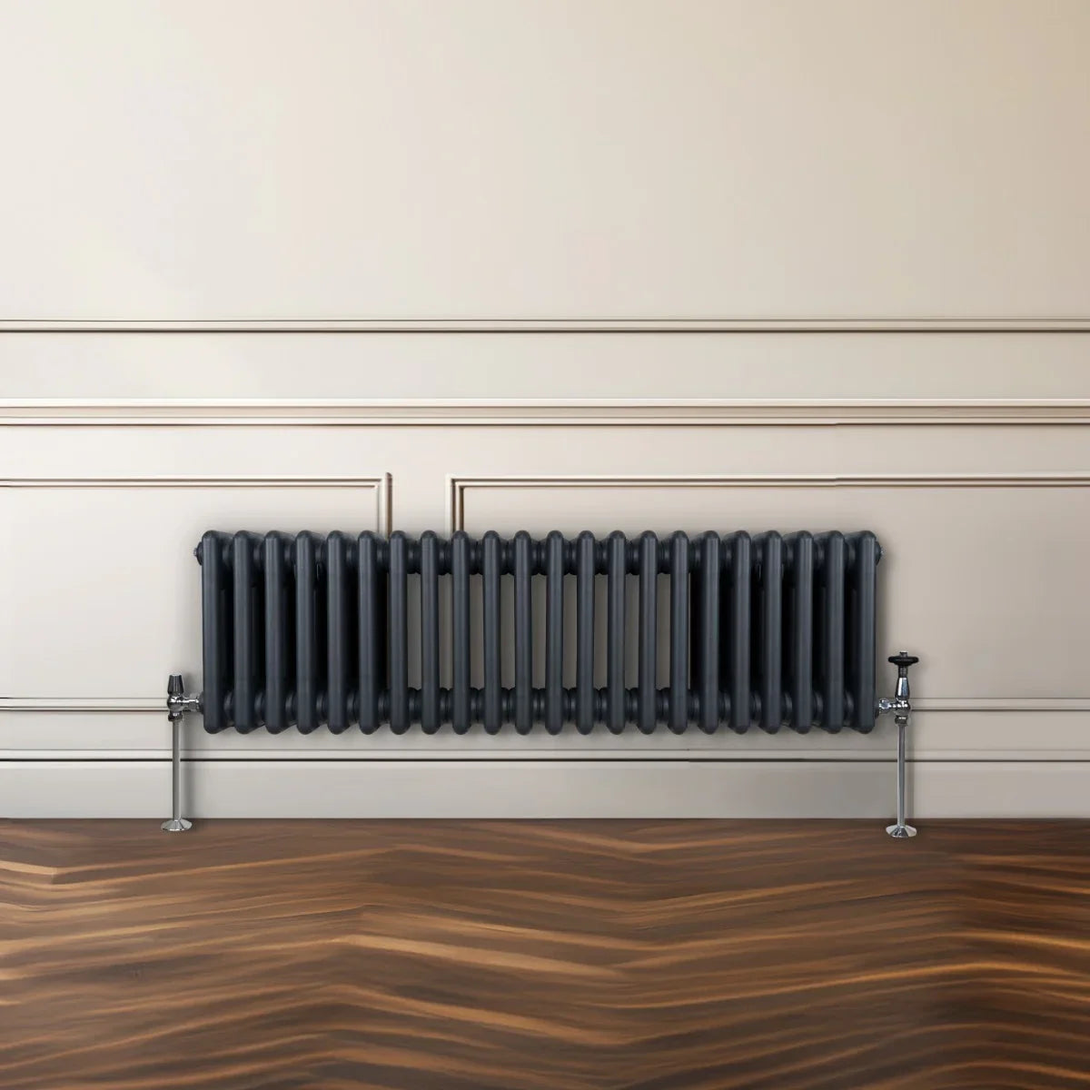 Traditional 3 column radiator in anthracite grey, featuring a sleek design with vertical fins and polished chrome valves against a neutral wall