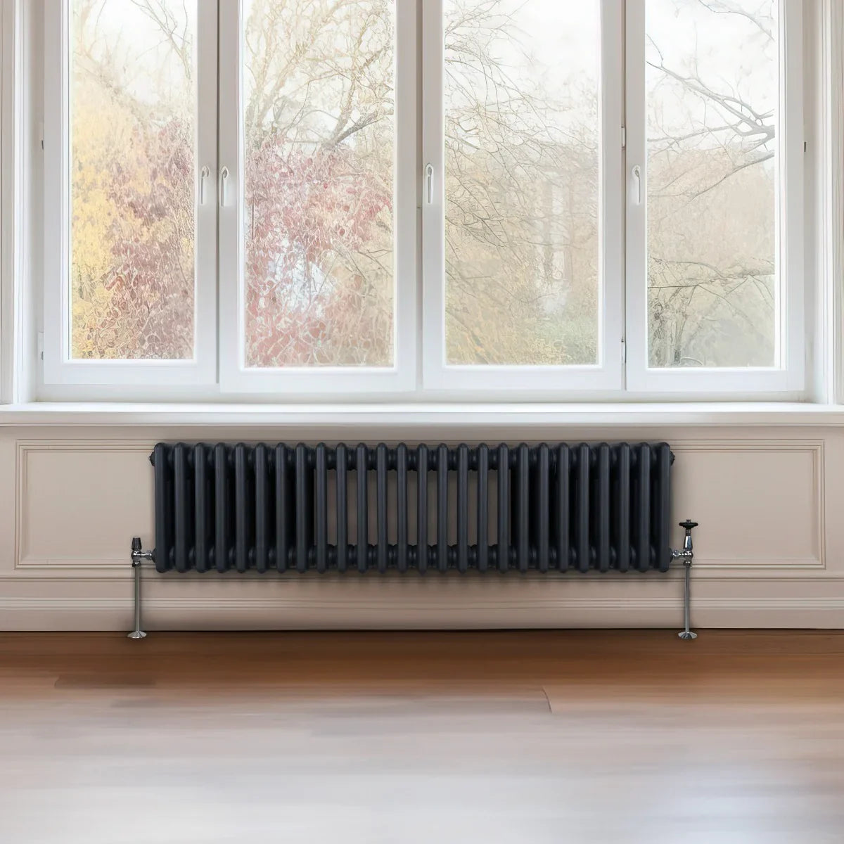 Traditional 3 column radiator in anthracite grey, featuring a sleek design, mounted beneath large windows with natural light
