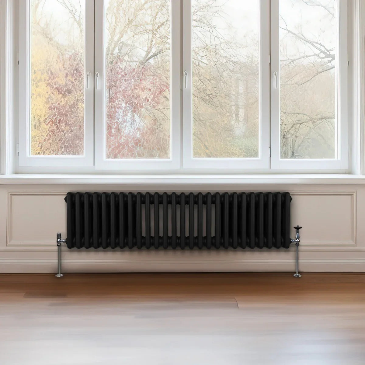 Traditional black 3 column radiator, 300 x 1192mm, featuring a sleek design with a smooth finish, positioned under large windows