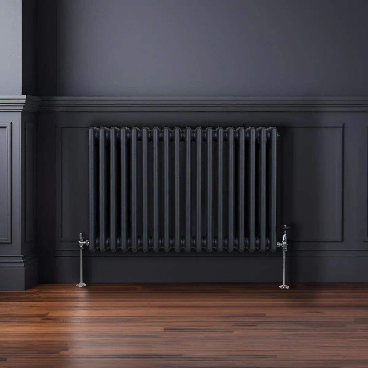 Traditional 3 column radiator in anthracite grey, featuring a sleek design with vertical fins, mounted on a wooden floor against a dark wall