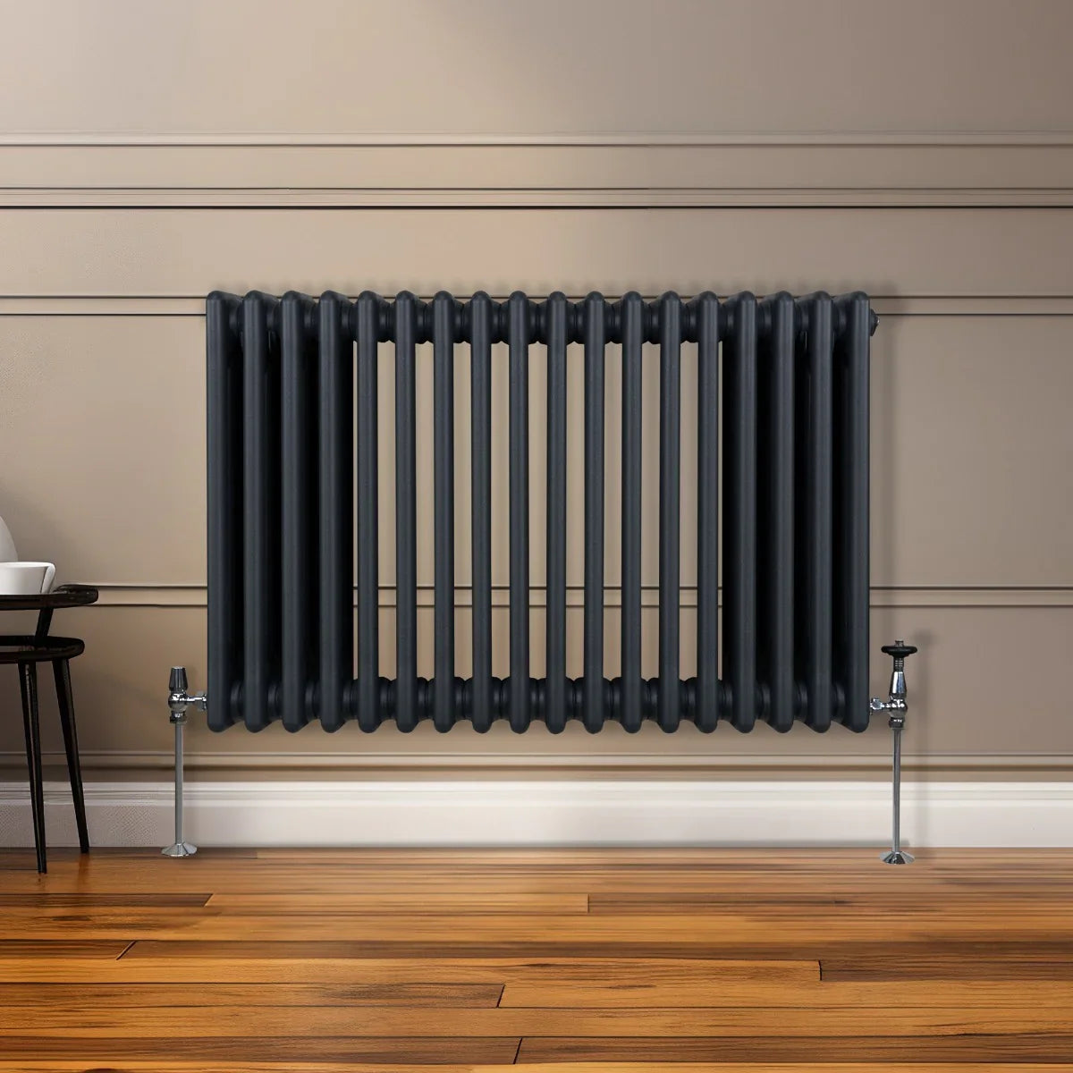 Traditional 3 column radiator in anthracite grey, featuring a sleek design with vertical bars, mounted on a wooden floor against a wall