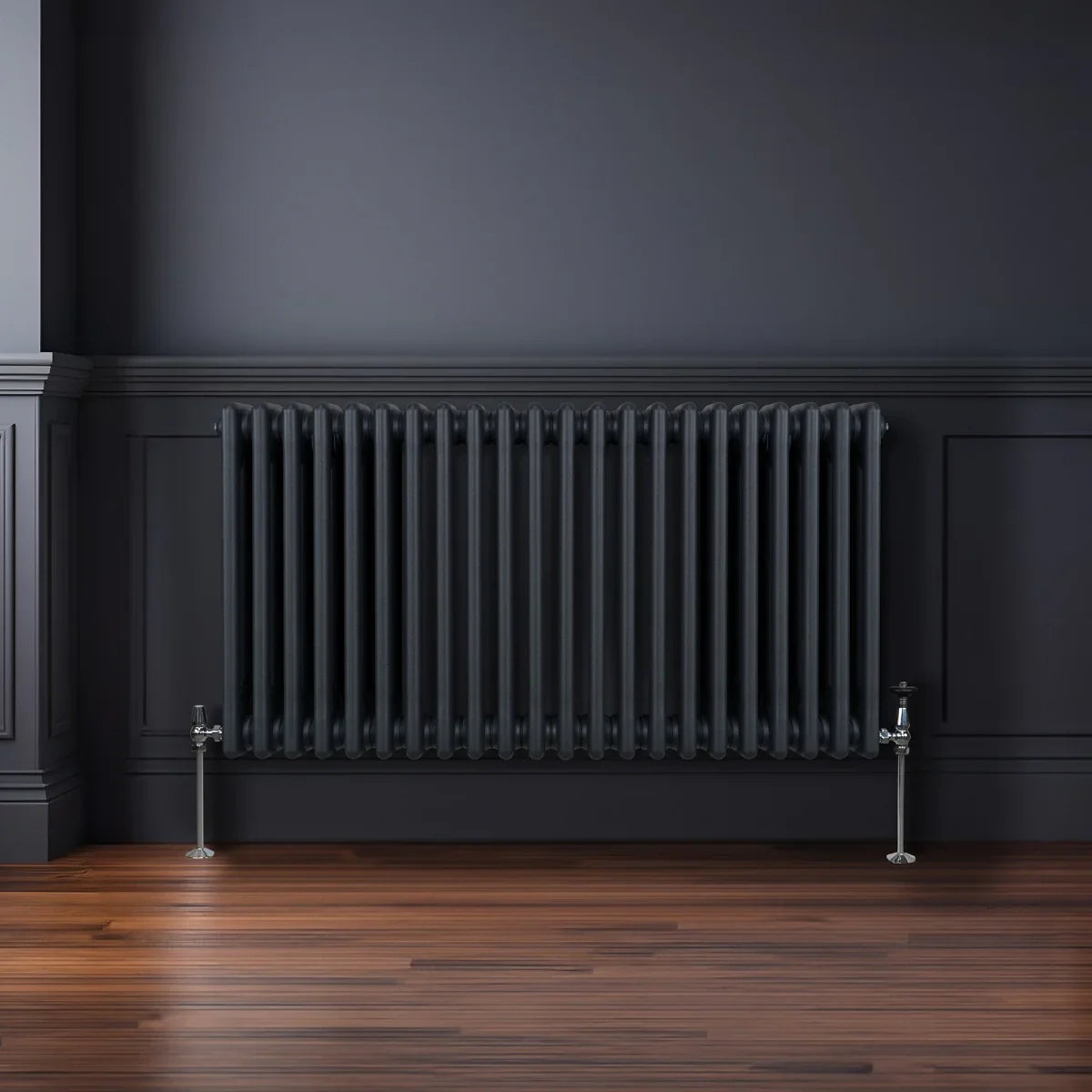 Traditional 3 column radiator in anthracite grey, featuring a sleek design with vertical fins, mounted on a dark wall above wooden flooring