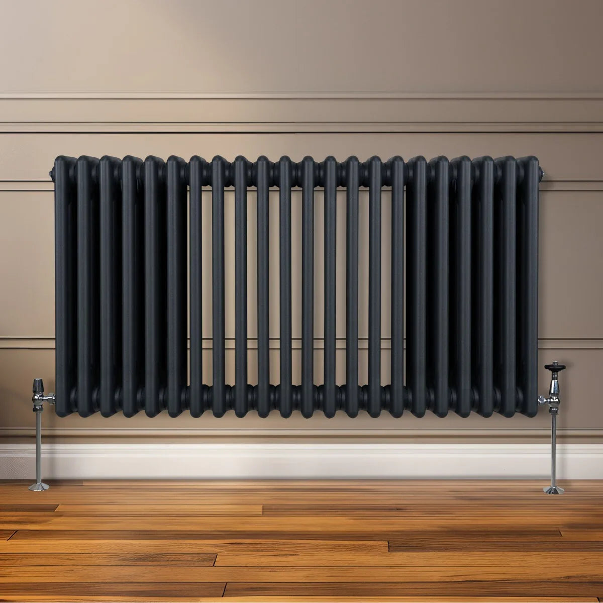 Traditional 3 column radiator in anthracite grey, featuring a sleek design with vertical bars, mounted on a wooden floor against a wall