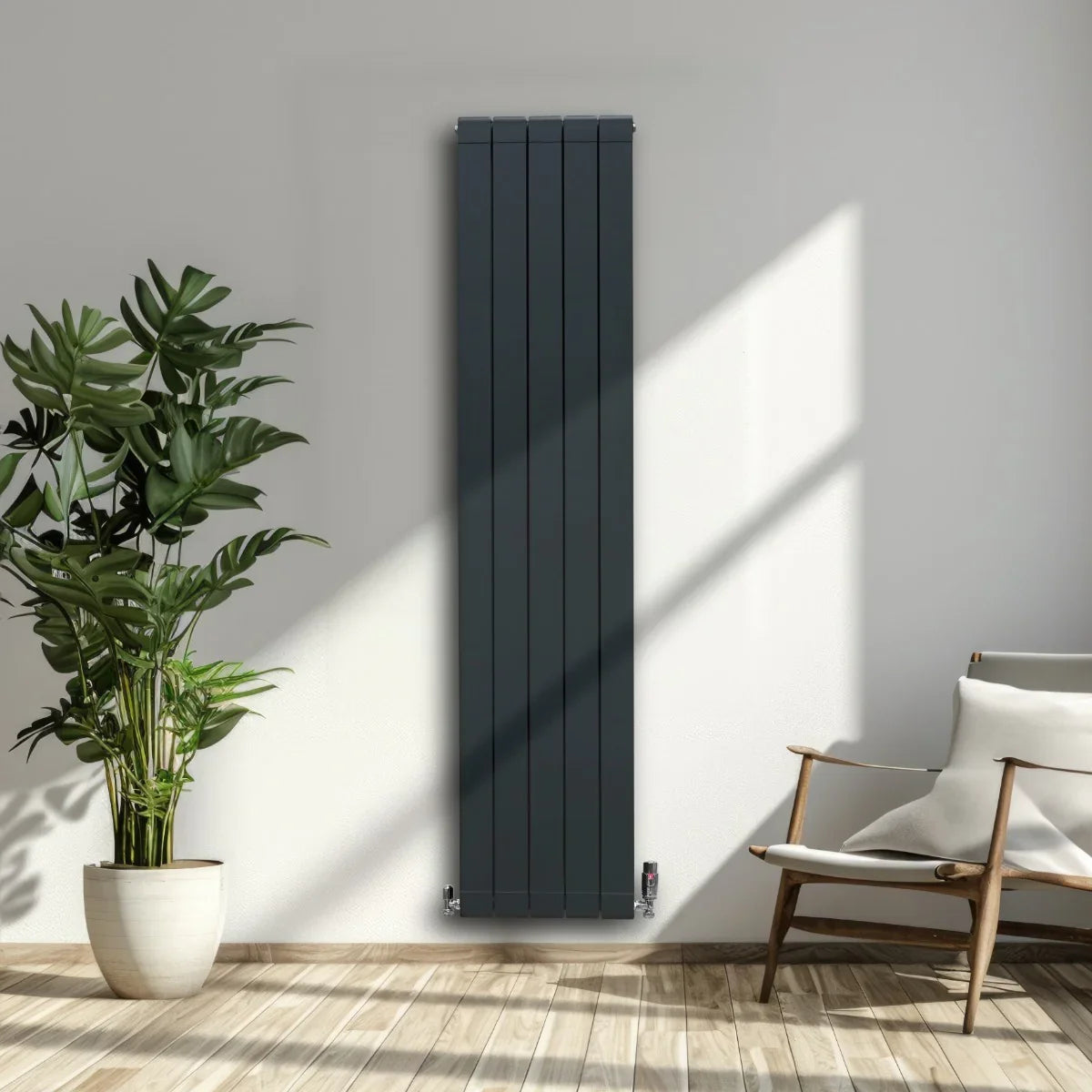 Slim anthracite grey aluminium radiator, 1800mm x 395mm, mounted on a bright wall, complemented by indoor plants and natural light