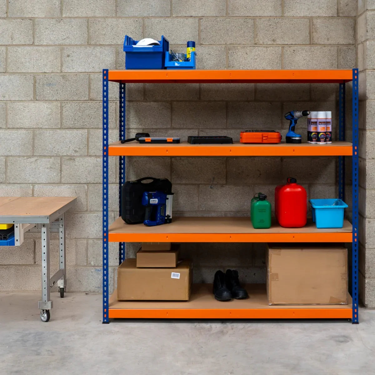 S-Rax 4 Shelf Racking in blue and orange, featuring sturdy metal shelves, organized tools, and storage boxes against a concrete wall