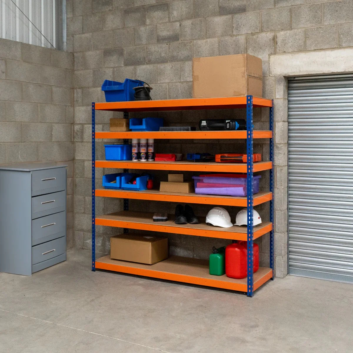 S-Rax 6 Shelf Racking in blue and orange, featuring sturdy metal shelves, organized with boxes, tools, and safety gear in a warehouse setting