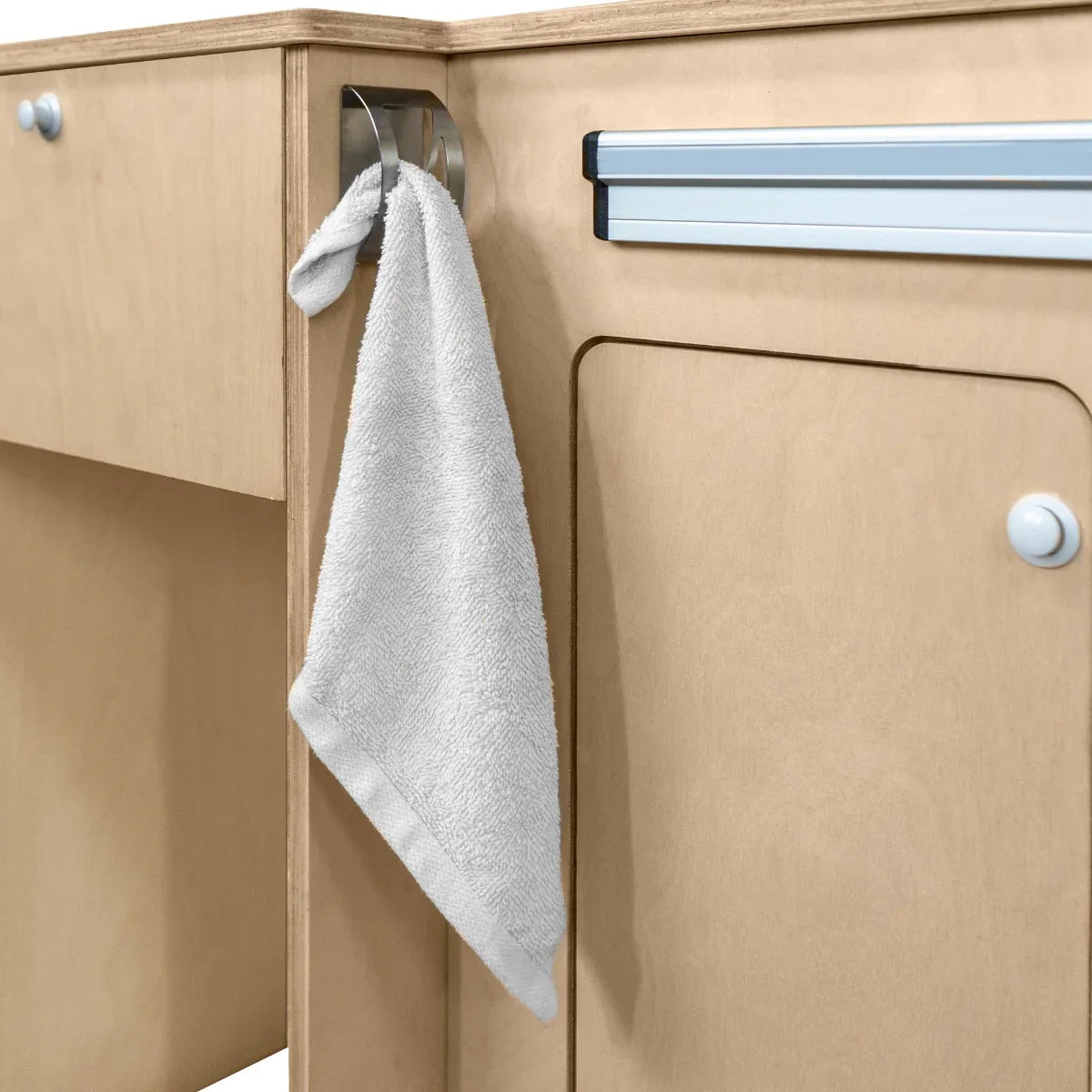 Soft gray towel hanging from a stainless steel hook on a light wood Camper Kitchen Pod, showcasing modern design and functionality