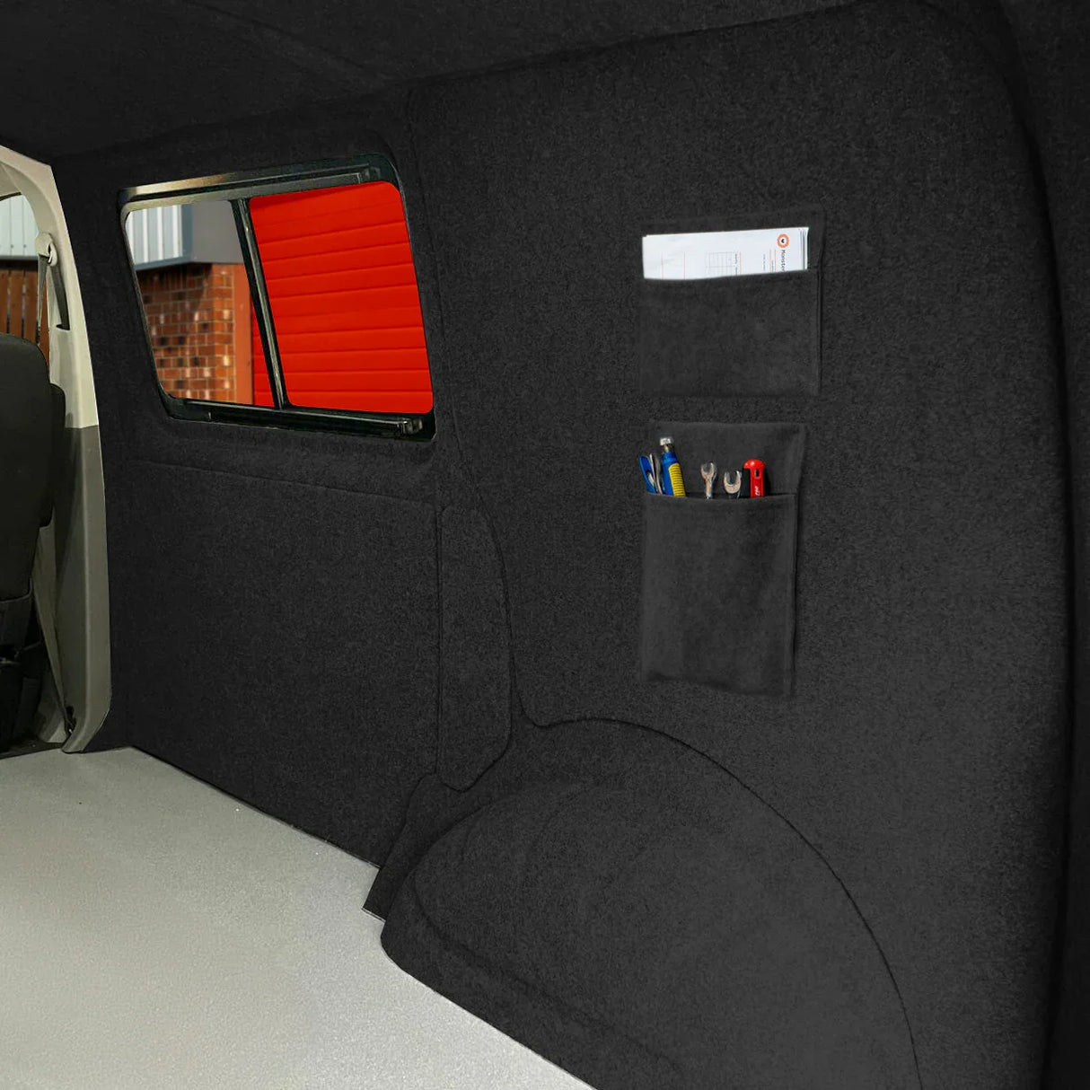 Anthracite grey van carpet lining with storage pouches, featuring a soft texture and organized tool storage for easy access