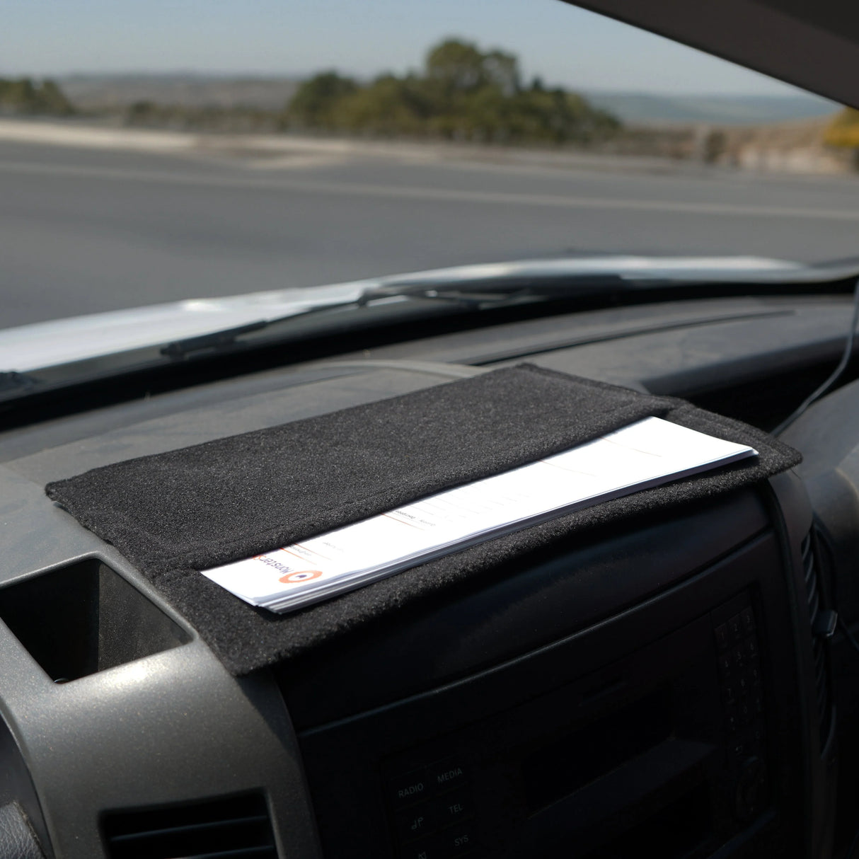 Anthracite grey van carpet lining with textured surface, featuring storage pouches for organizing documents and essentials