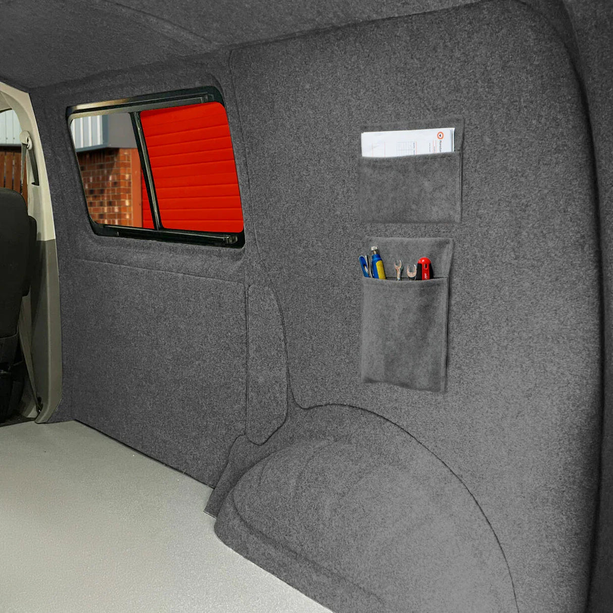 Smoke grey van carpet lining with storage pouches, featuring a soft texture and organized pockets for tools and accessories