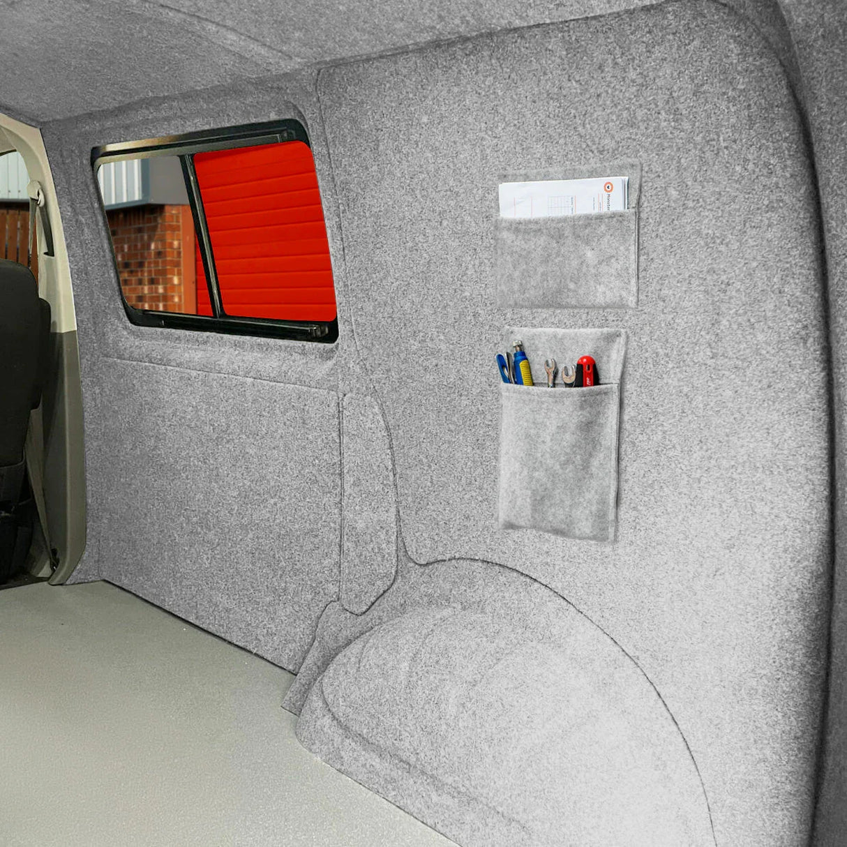 Silver grey van carpet lining with storage pouches, featuring a soft texture and organized compartments for tools and accessories