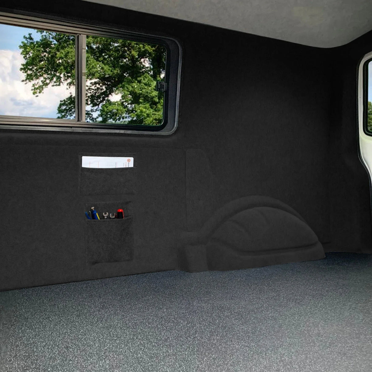 Anthracite grey van carpet lining with storage pouches, showcasing a smooth texture and a sleek, modern design in a vehicle interior