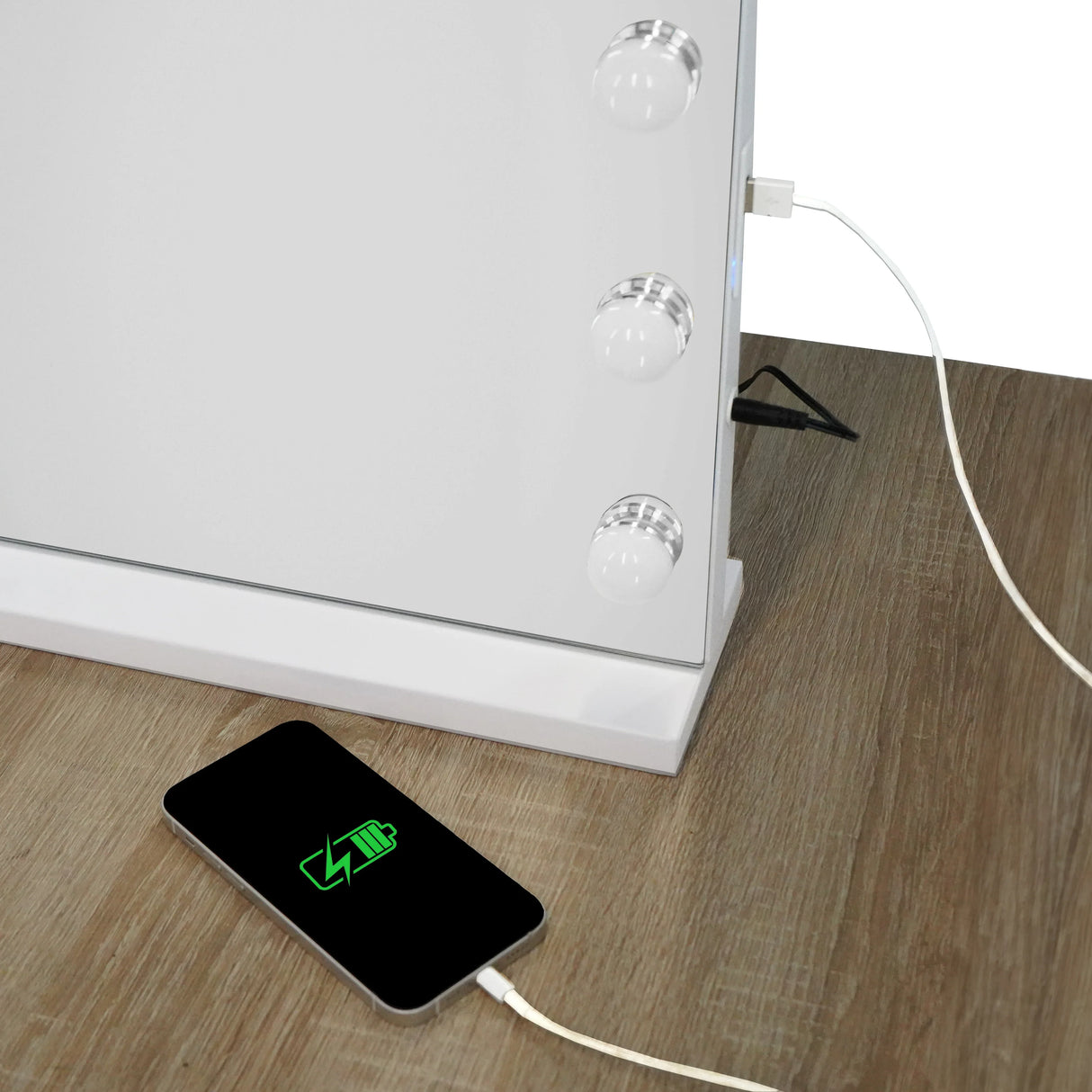 LED Bluetooth mirror with three round lights, sleek white frame, and USB charging port, placed on a wooden surface