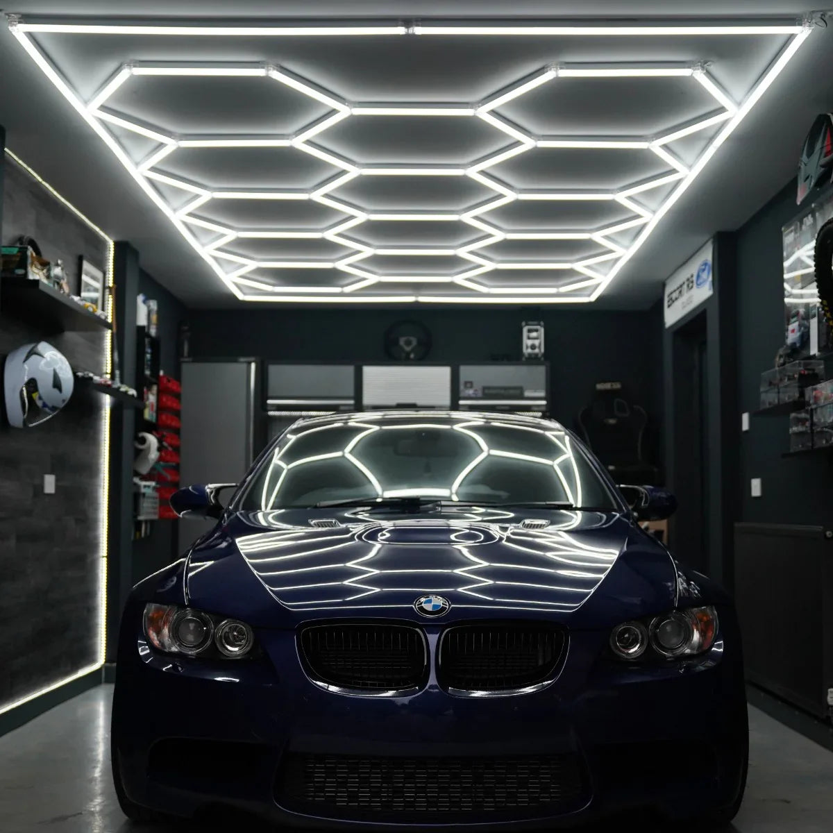 Hexagon LED lighting in a modern garage, illuminating a blue BMW with sleek, bright white light reflecting off surfaces