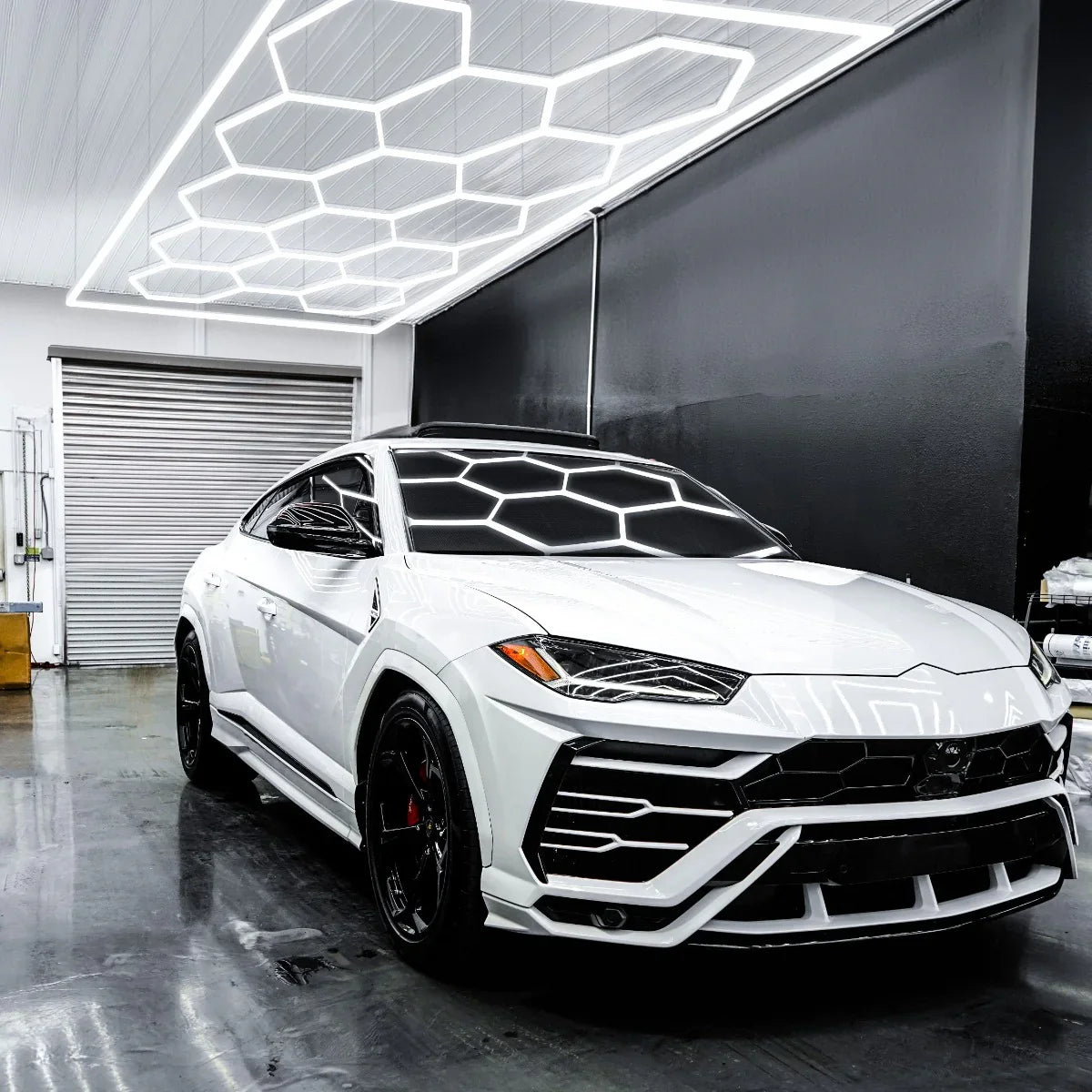 Hexagon LED lighting in a modern showroom illuminating a sleek white luxury SUV with a glossy finish and black accents