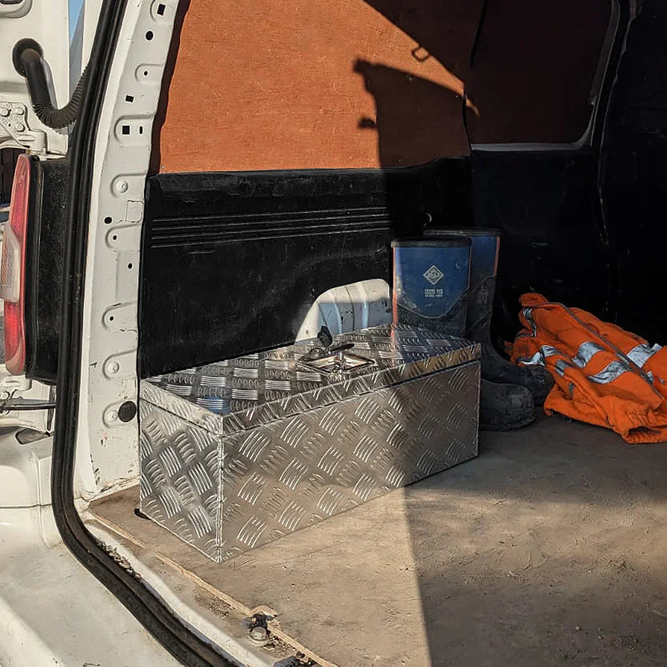 Aluminium tool box 60L in a vehicle's cargo area, featuring a diamond plate texture, shiny silver finish, and sturdy design