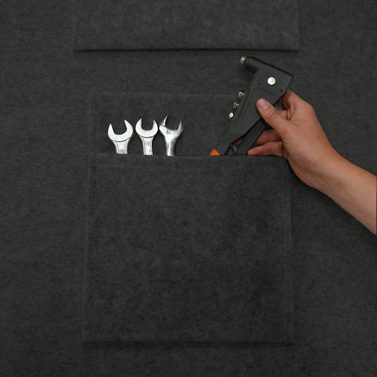 Anthracite grey storage pouches with a textured finish, holding tools like wrenches and a hand tool, ideal for organization