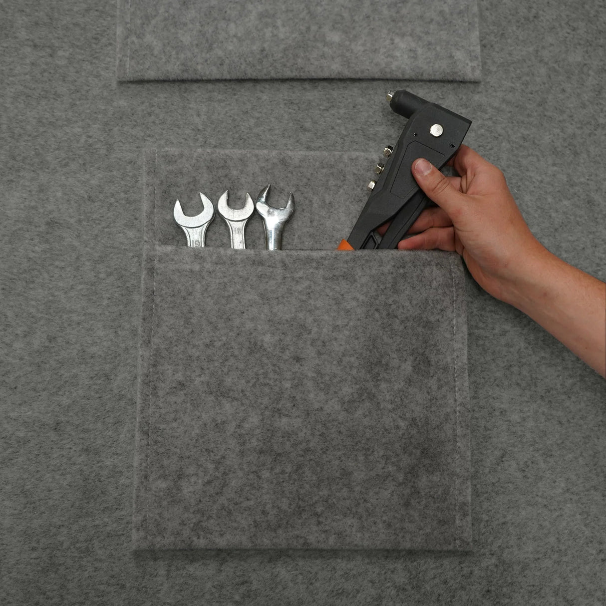 Smoke grey storage pouches made of felt, featuring multiple pockets holding various tools, ideal for organization and storage