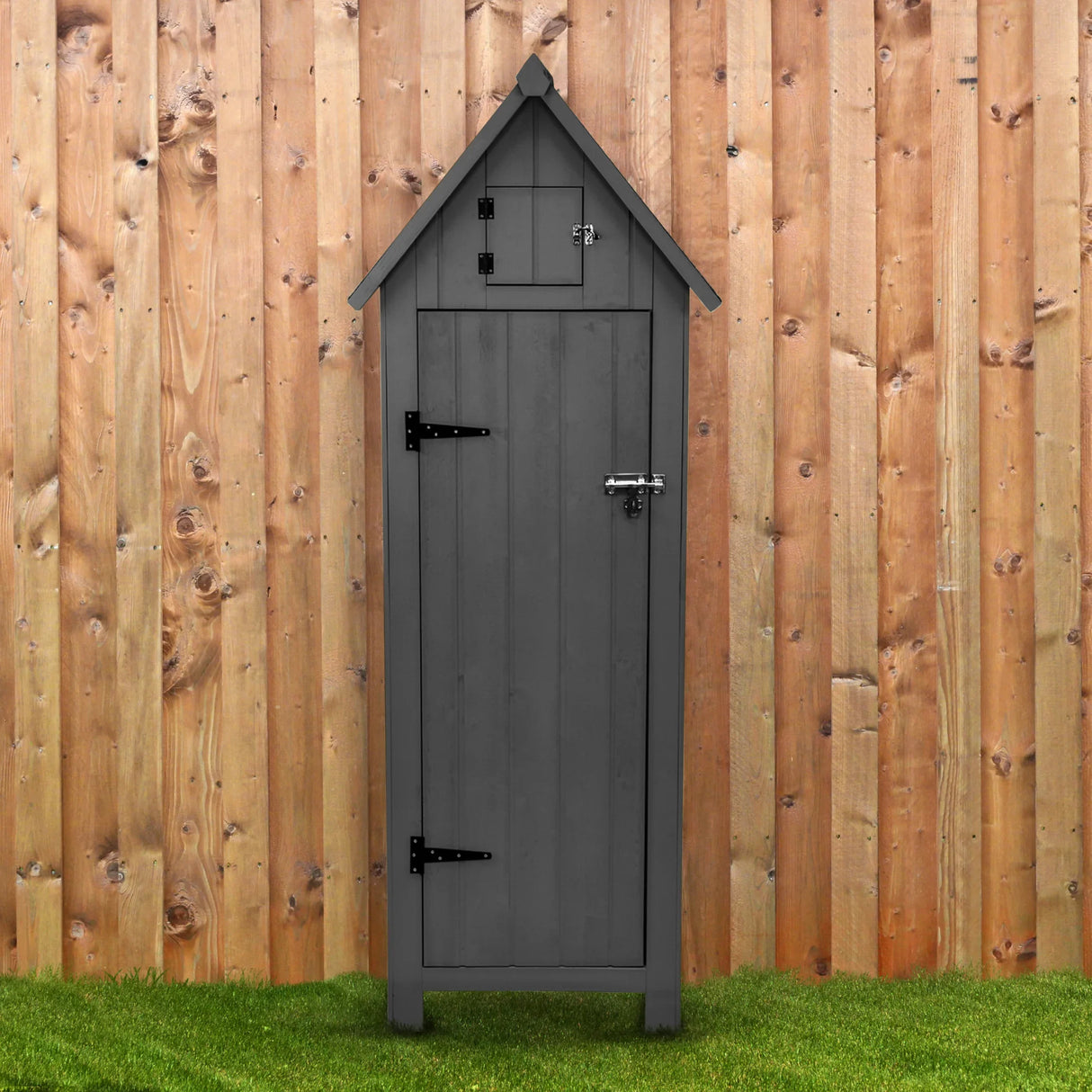 Dark grey wooden garden shed with a peaked roof, metal latch, and hinges, set against a rustic wooden fence and green grass